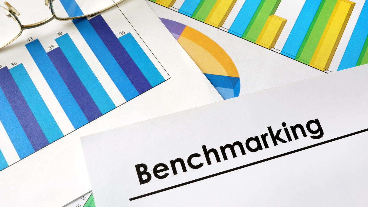 Financial charts and graphs surrounding a document titled "Benchmarking&rdquo;