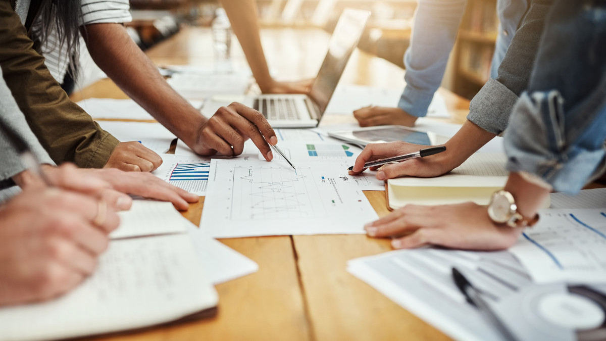 Business team collaboratively reviewing charts and financial documents on a table